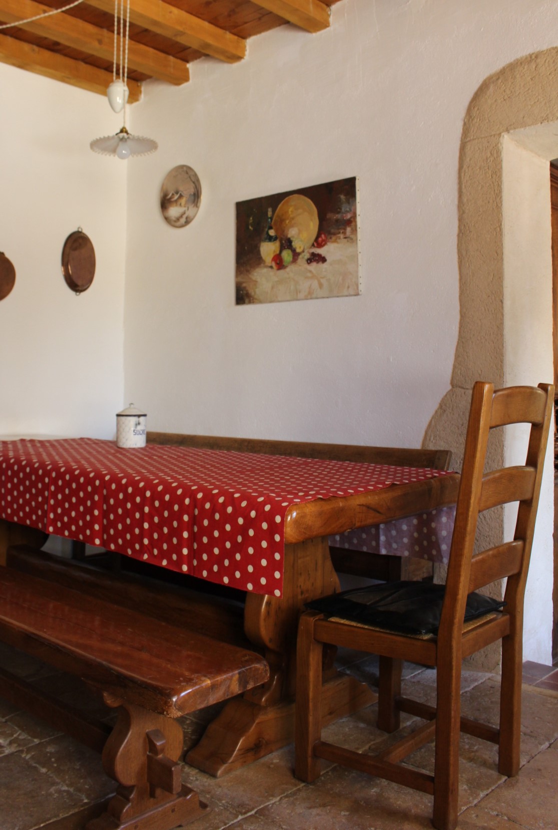 salon avec une table et nappe, deux bancs, une chaise